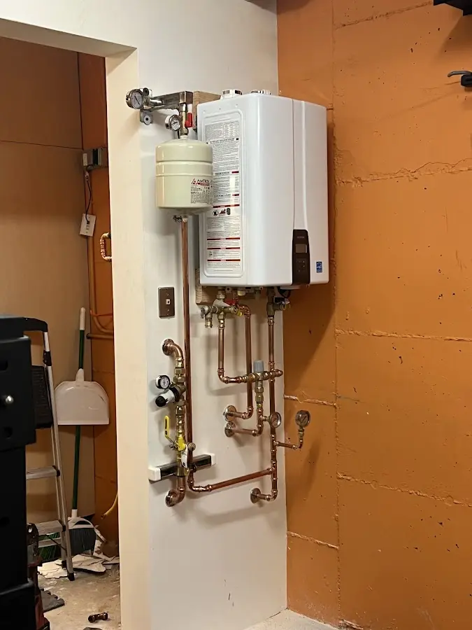 Plumbing technician inspecting water heater connections in Roanoke
